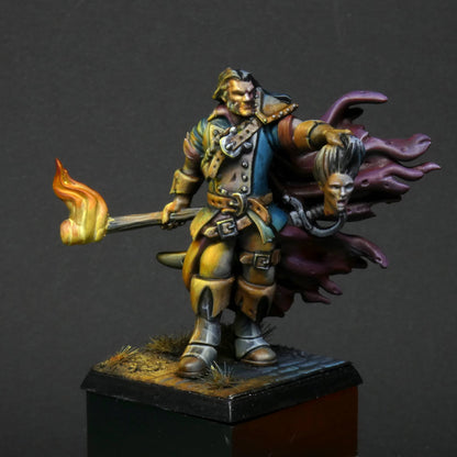 a 32mm scale miniature of Cristof Witchbane, a rugged witch hunter wielding a flaming torch and a severed witch's head.  The model is viewed painted beautifully with excellent lighting effects from the fire of the torch. 